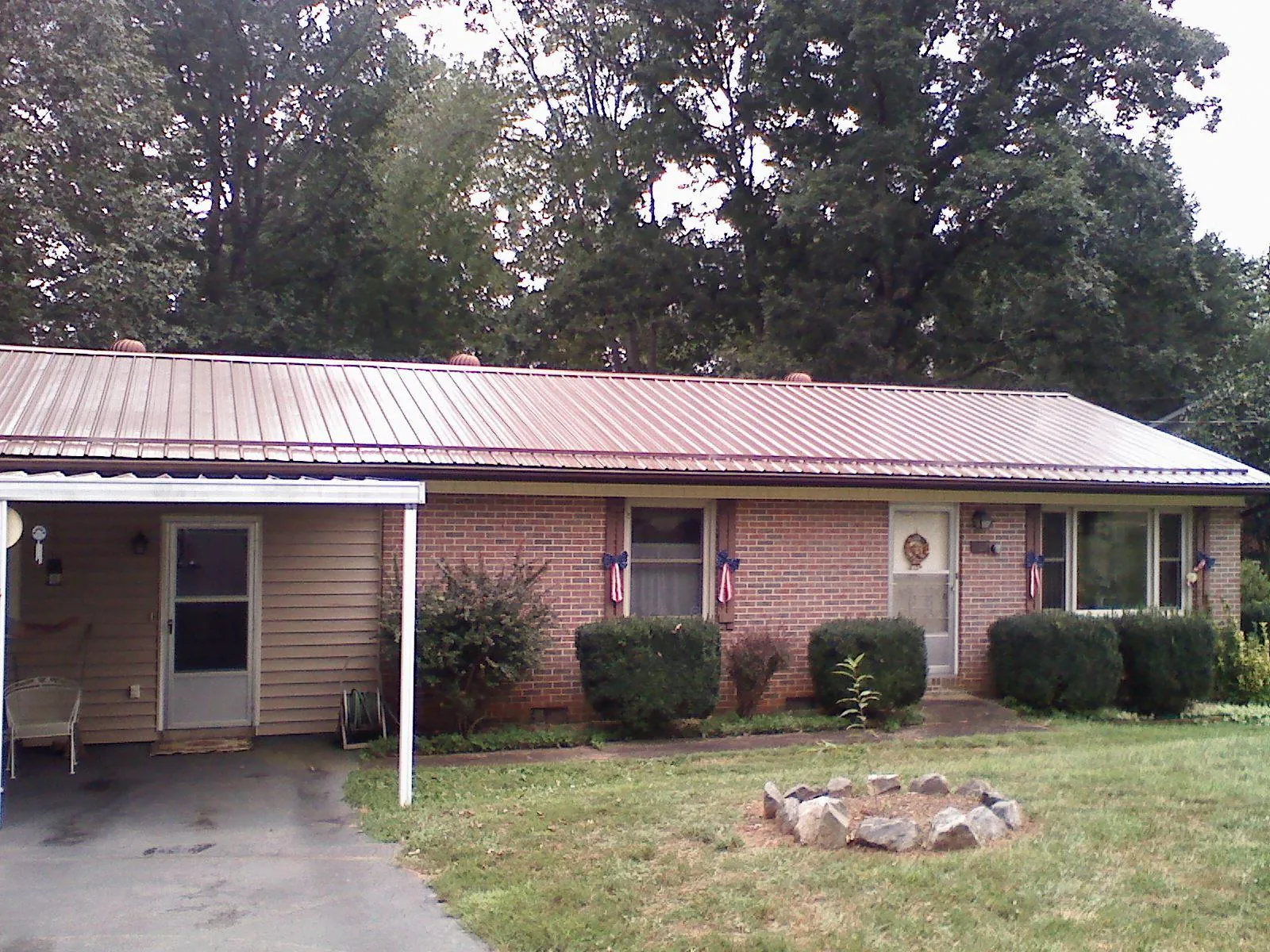 Bronze metal roof and carport on a brick ranch home — Roof Repair work by our crew in Fenton